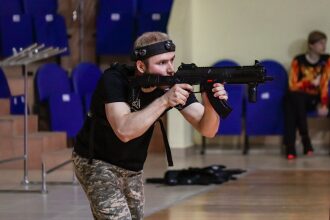 Боец LASERWAR наводит прицел на цель в помещении